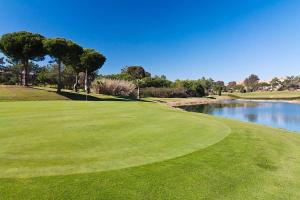 uma vista para um campo de golfe com um lago em Islantilla - Bajo con Jardín en Golf Islantilla em Huelva