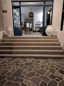 um lobby com escadas com vasos no chão em Hotel Flisvos em Megalochori