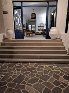 un atrio con scale con vasi sul pavimento di Hotel Flisvos a Megalochori (Isola di Agistri)