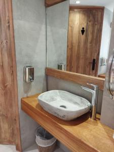 メガロホリにあるHotel Flisvosのバスルーム(白い洗面台、木製カウンター付)