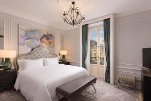 - une chambre avec un lit blanc et un lustre dans l'établissement Hotel Maria Cristina, a Luxury Collection Hotel, San Sebastian, à Saint-Sébastien
