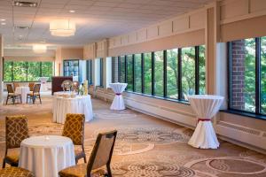 a banquet hall with tables and chairs and windows at Sheraton Harrisburg Hershey Hotel in Harrisburg