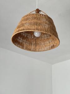 une lampe en rotin suspendue au plafond dans l'établissement Trullo Moi, à Ostuni