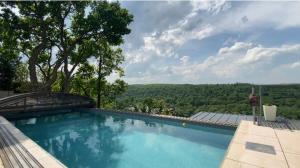 einen großen Pool mit Blick auf die Bäume in der Unterkunft Chatka - A - Vyhlídka nad řekou in Zdiby