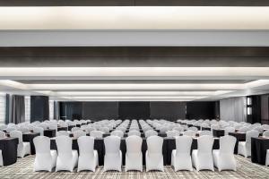a conference room with white chairs and a stage at Four Points by Sheraton Chengdu Tianfu New Area in Chengdu