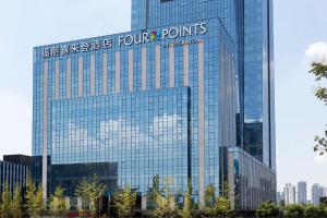 a tall glass building with a sign on it at Four Points by Sheraton Chengdu Tianfu New Area in Chengdu