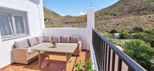 a patio with a table and chairs on a balcony at Vistas mar y montaña LasNegras in Las Negras