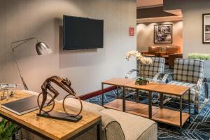 a living room with furniture and a flat screen tv at Four Points by Sheraton Boston Logan Airport Revere in Revere