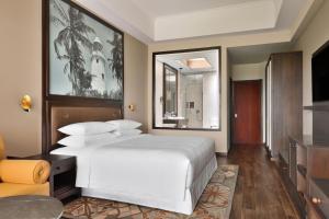 a bedroom with a white bed and a television at Sheraton Kosgoda Turtle Beach Resort in Bentota