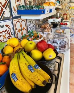 - un bouquet de bananes et d'autres fruits sur un comptoir dans l'établissement La Maison Derrière, à Tropea