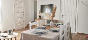 uma sala de jantar branca com uma mesa e cadeiras em Vistas mar y montaña LasNegras em Las Negras