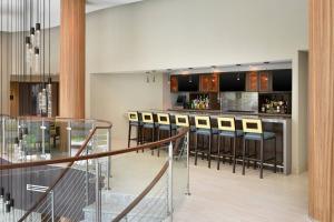 a lobby with a bar with stools at Four Points by Sheraton Coral Gables in Miami