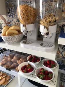 une étagère avec des bols de fraises et de pâtisseries dans l'établissement La Maison Derrière, à Tropea