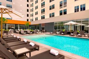 a swimming pool with lounge chairs and a hotel at Aloft Dallas Love Field in Dallas