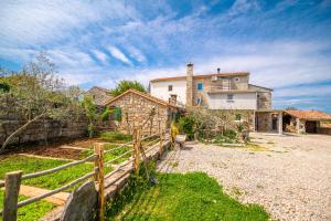 a house with a fence in front of a yard at Betlehem & Nazaret cottage on Krk island in Krk