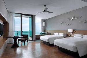 格林的住宿－Rayong Marriott Resort & Spa，酒店客房设有两张床和电视。