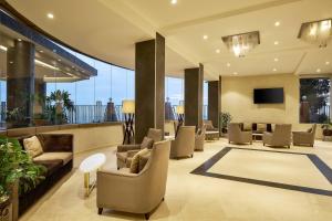 a lobby with couches and chairs in a building at Protea Hotel by Marriott Kampala Skyz in Kampala