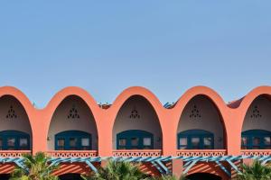 an orange building with windows and palm trees at Sheraton Miramar Resort El Gouna in Hurghada