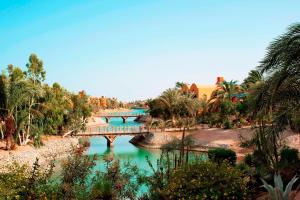 a bridge over a river in a park with trees at Sheraton Miramar Resort El Gouna in Hurghada