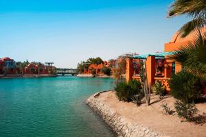 a river with houses and a bridge in the background at Sheraton Miramar Resort El Gouna in Hurghada