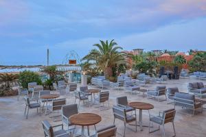 a patio with tables and chairs and palm trees at Sheraton Miramar Resort El Gouna in Hurghada