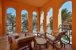 a room with orange walls and chairs and windows at Sheraton Miramar Resort El Gouna in Hurghada