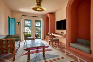 a living room with orange walls and a table and chairs at Sheraton Miramar Resort El Gouna in Hurghada