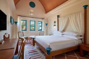 a bedroom with a bed and a table and chairs at Sheraton Miramar Resort El Gouna in Hurghada