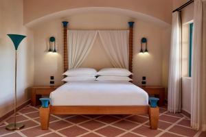 a bedroom with a bed with white sheets and pillows at Sheraton Miramar Resort El Gouna in Hurghada