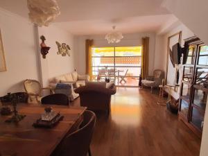 ein Wohnzimmer mit Tisch und Couch in der Unterkunft Suites Beach House in Playa de las Americas