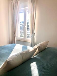 1 dormitorio con cama con almohadas y ventana en Beautiful view apartment with garage space, en Mali Lošinj