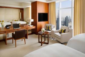 a hotel room with a bed and a desk with a computer at JW Marriott Marquis Hotel Dubai in Dubai