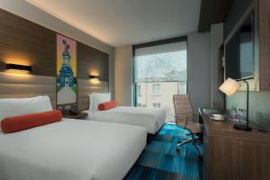 a hotel room with two beds and a window at Aloft Dublin City in Dublin