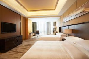 Gu'anにあるFour Points by Sheraton Langfang, Gu'anのベッド2台、薄型テレビが備わるホテルルームです。