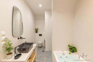 ein Badezimmer mit Waschbecken, Badewanne und Spiegel in der Unterkunft Luxury Home & Great Location in Athen