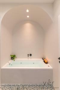 eine weiße Badewanne in einem weiß ummauerten Badezimmer in der Unterkunft Luxury Home & Great Location in Athen