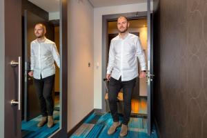 a man walking through a door in a mirror at Aloft Dublin City in Dublin