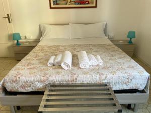 um quarto com uma cama com três pares de chinelos brancos em CASA VACANZE Affittacamere Senigallia 158 em Senigallia