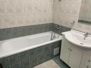 a bathroom with a white tub and a sink at Marina Cape SP private apartments in Aheloy