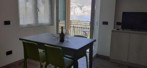 a dining room table with a bottle of wine and chairs at APPARTAMENTO LECCINO in Malcesine