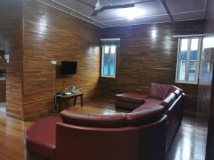a waiting room with a leather couch and a tv at Sandakan Sim Sim Homestay in Sandakan