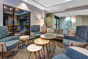 TownePlace Suites by Marriott Nashville Airport في ناشفيل: غرفة انتظار مع كراسي وطاولات زرقاء