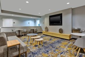 a waiting room with tables and a flat screen tv at TownePlace Suites by Marriott Nashville Airport in Nashville