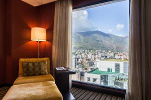 um quarto com uma grande janela com vista para a cidade em Renaissance Caracas La Castellana Hotel em Caracas