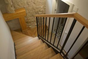 escalera con barandilla de madera y pared de piedra en En BLANCO y TINTO, en Elciego