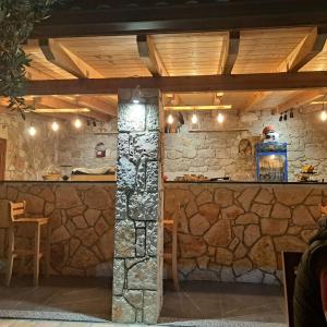希馬拉的住宿－Hotel Mesun Himare，石质酒吧设有石墙和木制天花板