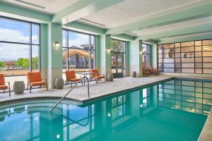 a swimming pool with chairs and tables in a building at The Westin Westminster in Westminster