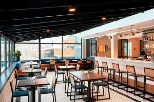a restaurant with tables and chairs and a bar at The Wick, Hudson, a Tribute Portfolio Hotel in Hudson