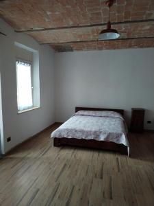 um quarto com uma cama e piso em madeira em cascina carlo em Aie