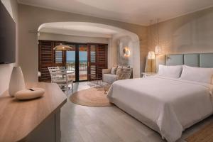 a bedroom with a large bed and a living room at The Westin La Quinta Golf Resort & Spa, Benahavis, Marbella in Marbella